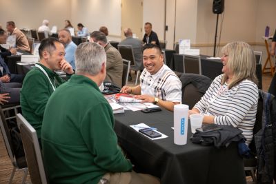 4 Attendees sitting around a table talking during IMPACTful Connections